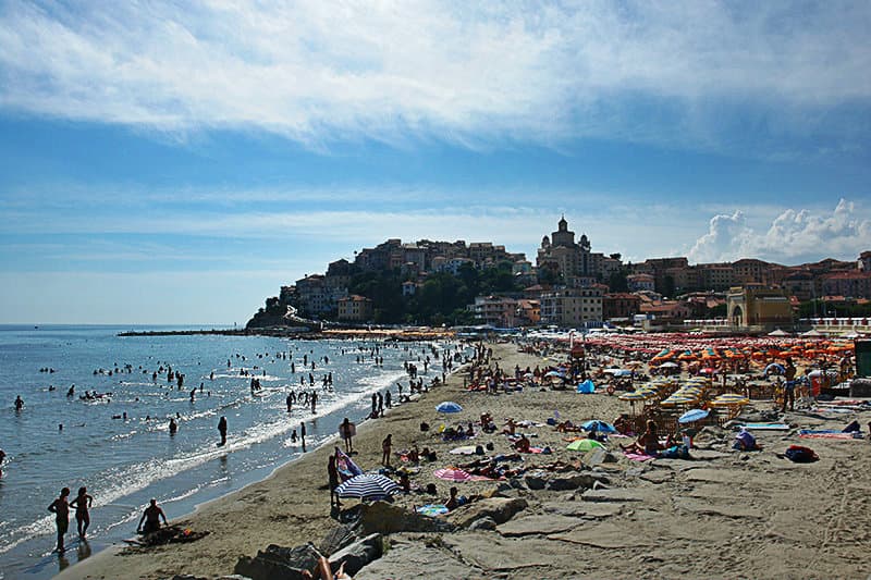 People are enjoying the sun at the sandy beach of Imperia
