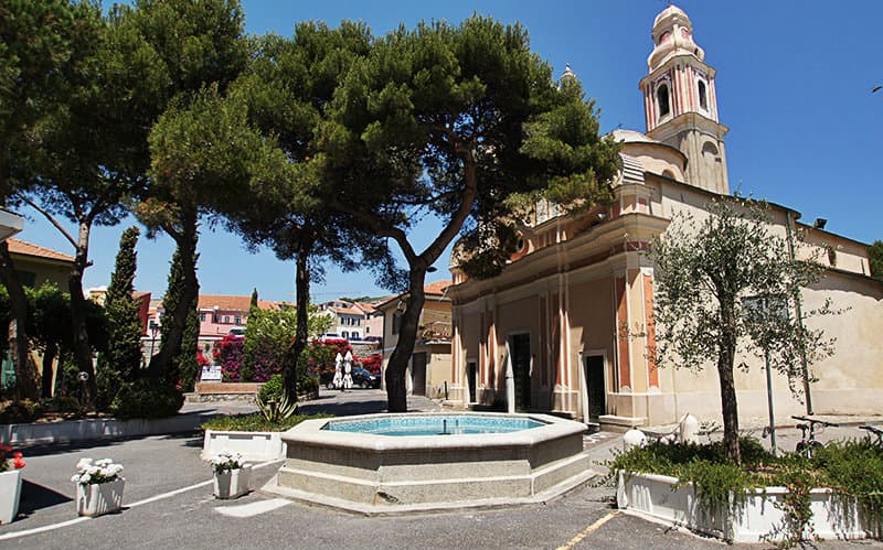A beautiful fountain next to a church in San Lorenzo al Mare