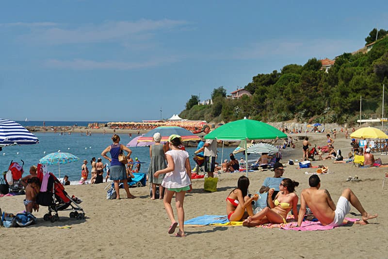 People are enjoying the sun in a sandy beach of San Lorenzo al Mare
